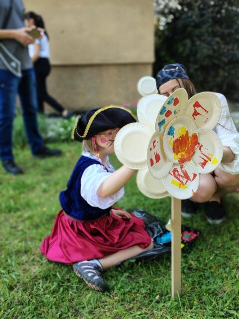 Uczestniczka warsztatów maluje kwiaty.